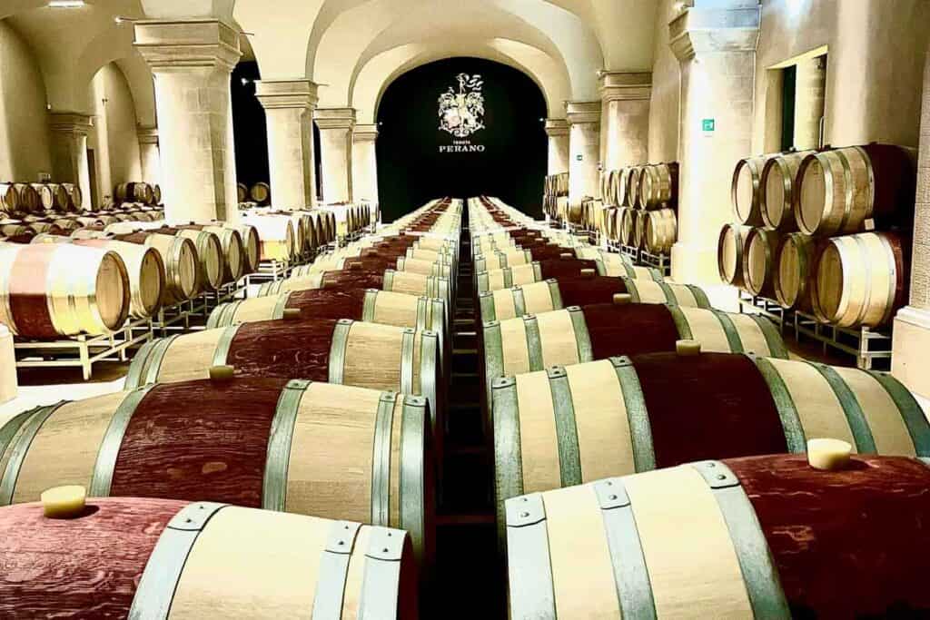 A row of wooden barrels in a wine cellar.