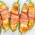 Bacon wrapped jalapenos on a white plate.