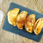 A plate of empanadas on a slate.