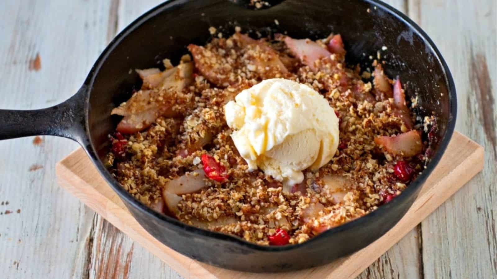 Apple crisp in a skillet with ice cream.