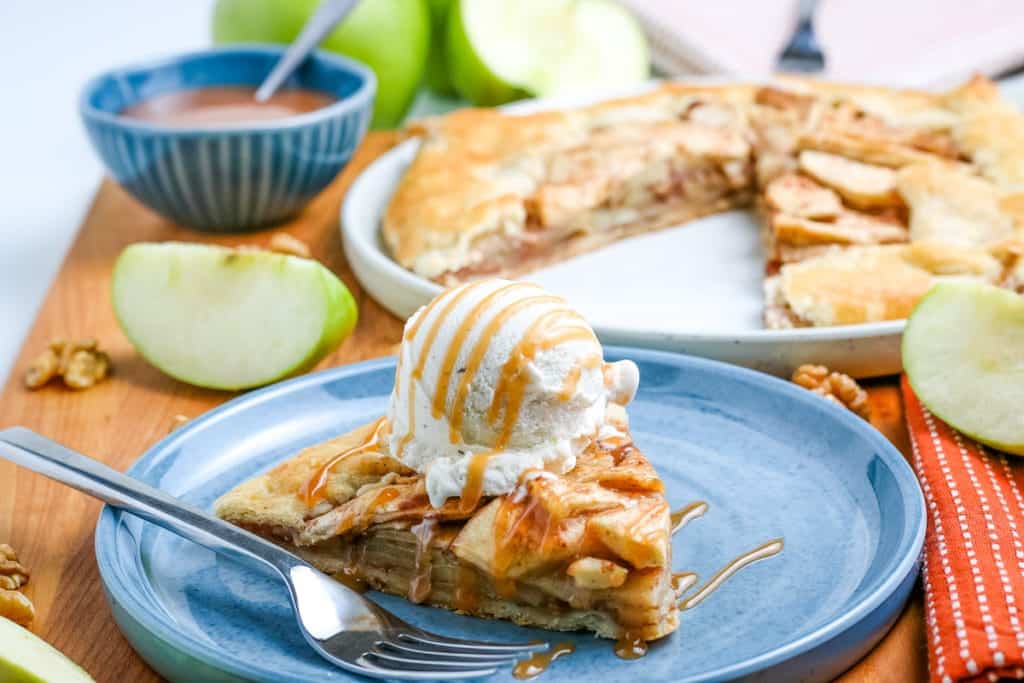 A slice of apple galette with ice cream on a plate.