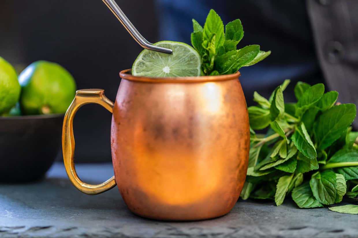A moscow mule with lime and mint in a copper mug.