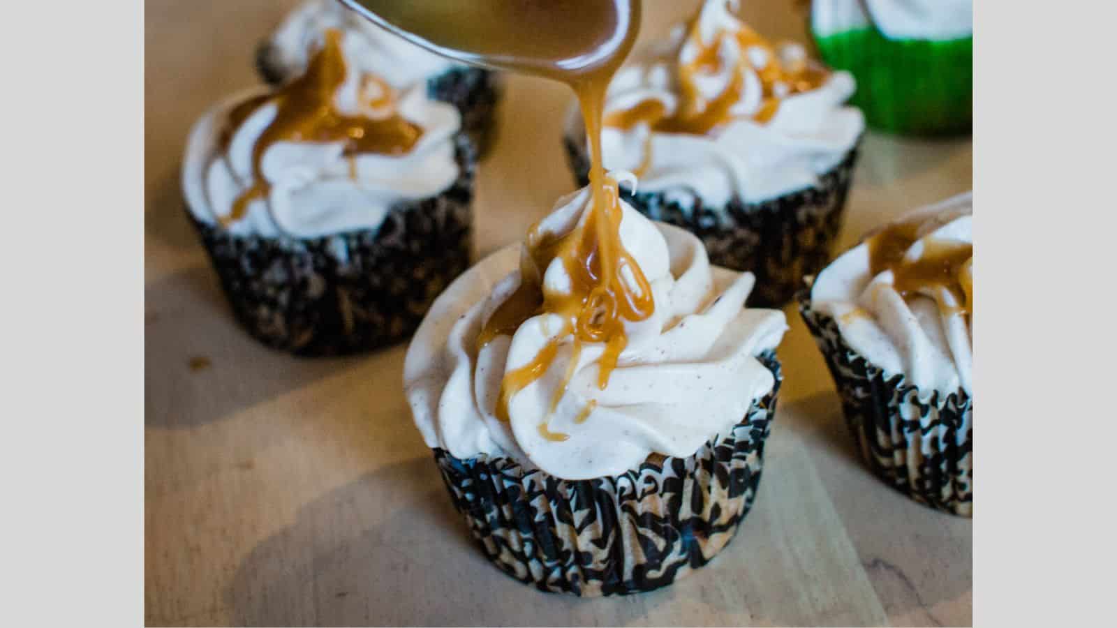 Caramel cupcakes with whipped cream and caramel drizzle.