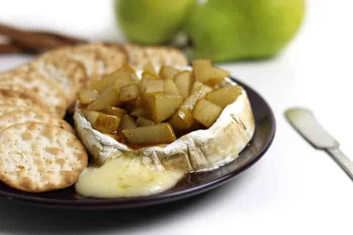A plate of caramelized pears and crackers.