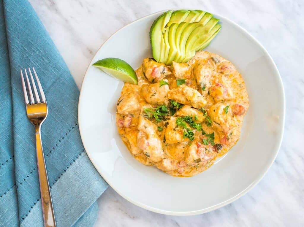 A white plate with chicken Taco Casserole avocado on it.