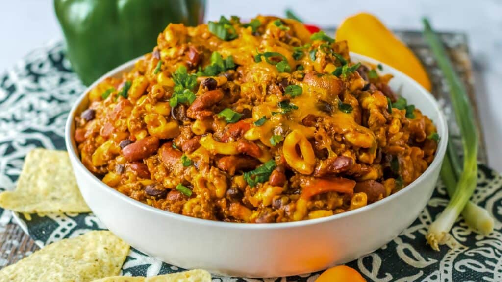 Chili mac in a bowl with tortilla chips.