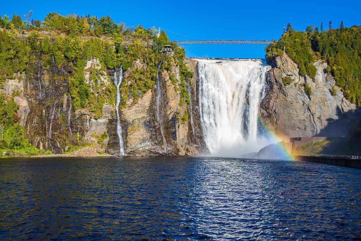 Keywords: waterfall, Québec City. Modified description: A stunning rainbow graces the skies above a majestic waterfall in Québec City.