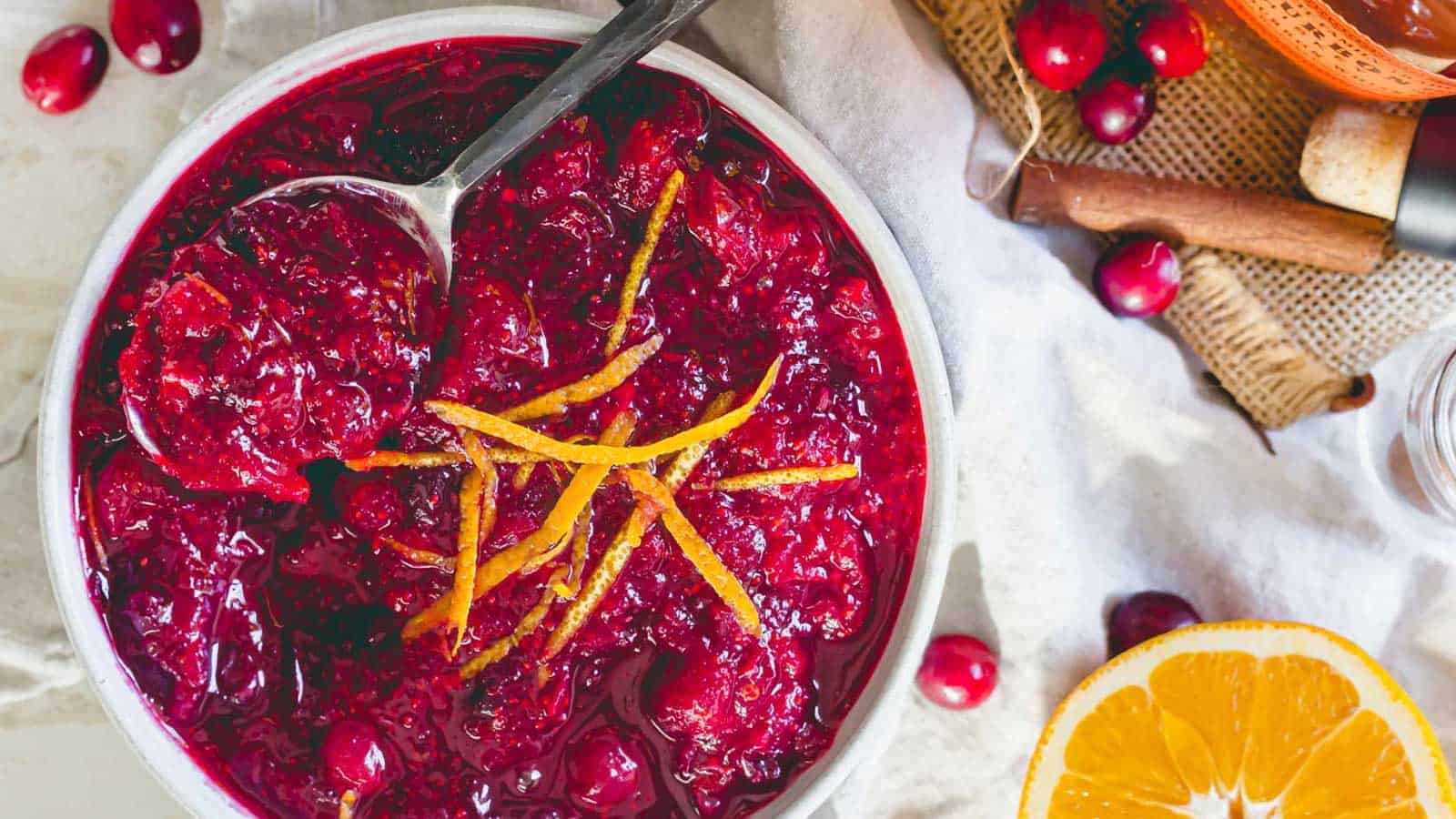 Bourbon cranberry sauce in a white bowl with orange slices.