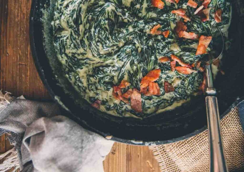 Spinach and bacon in a skillet.