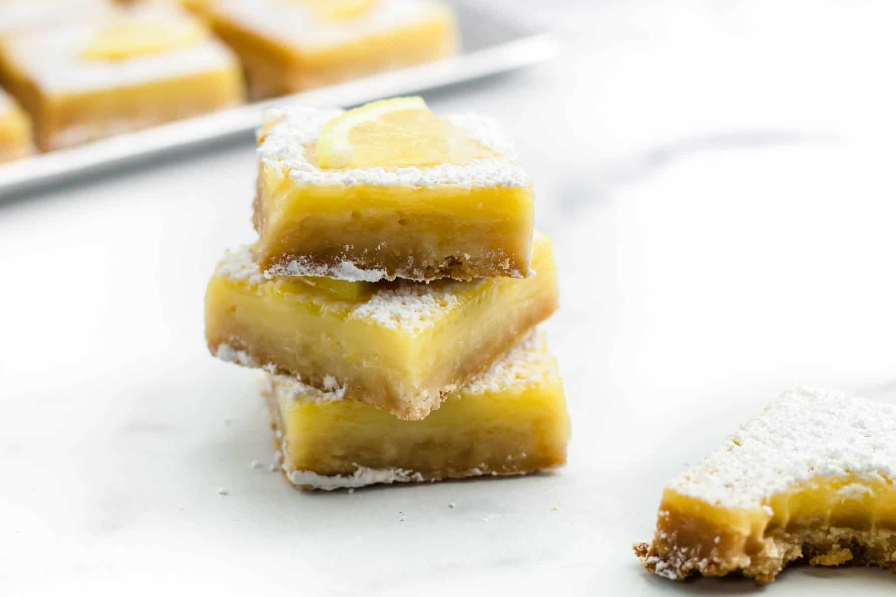 A stack of lemon bars with powdered sugar on top.