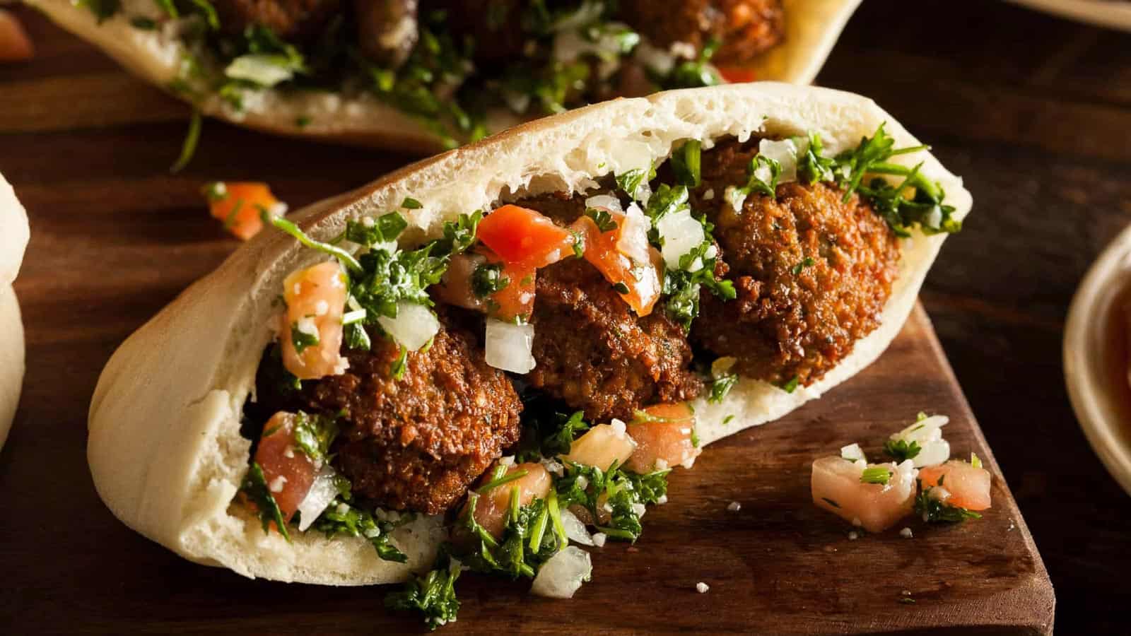 Low angle shot of falafel in a pita with parsley and tomatoes.
