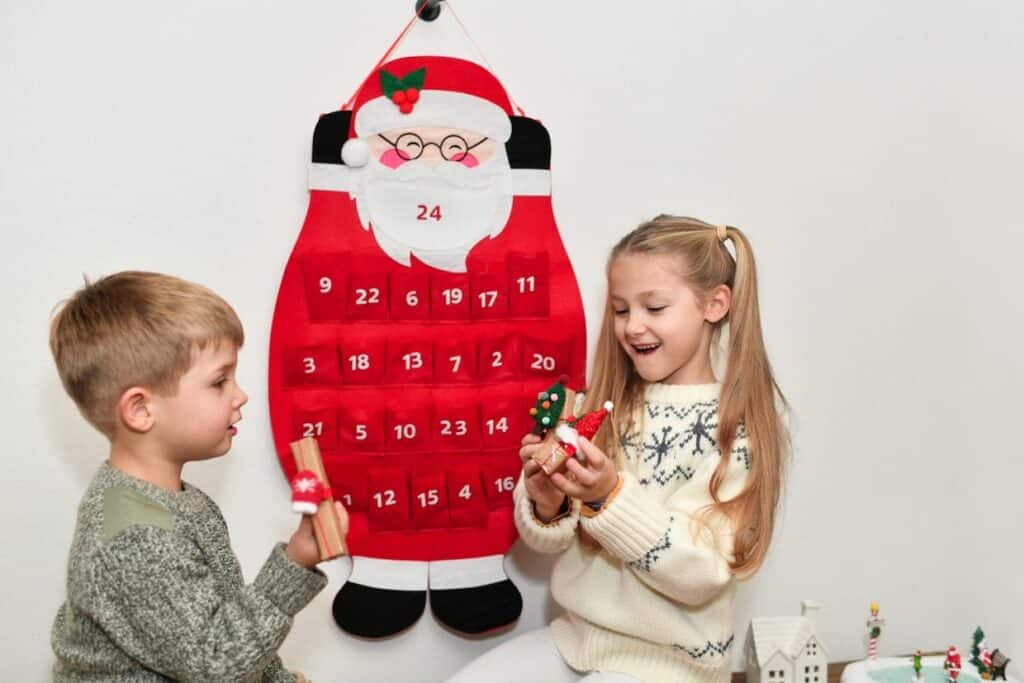 Two children playing with a festive advent calendar.