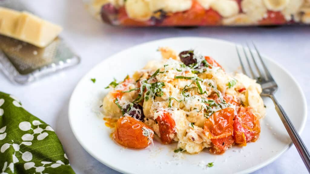 A plate of pasta with tomatoes and cheese on it.