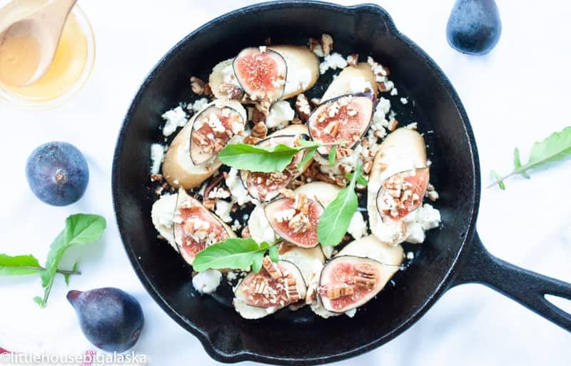 Fig and goat cheese stuffed figs in a skillet.