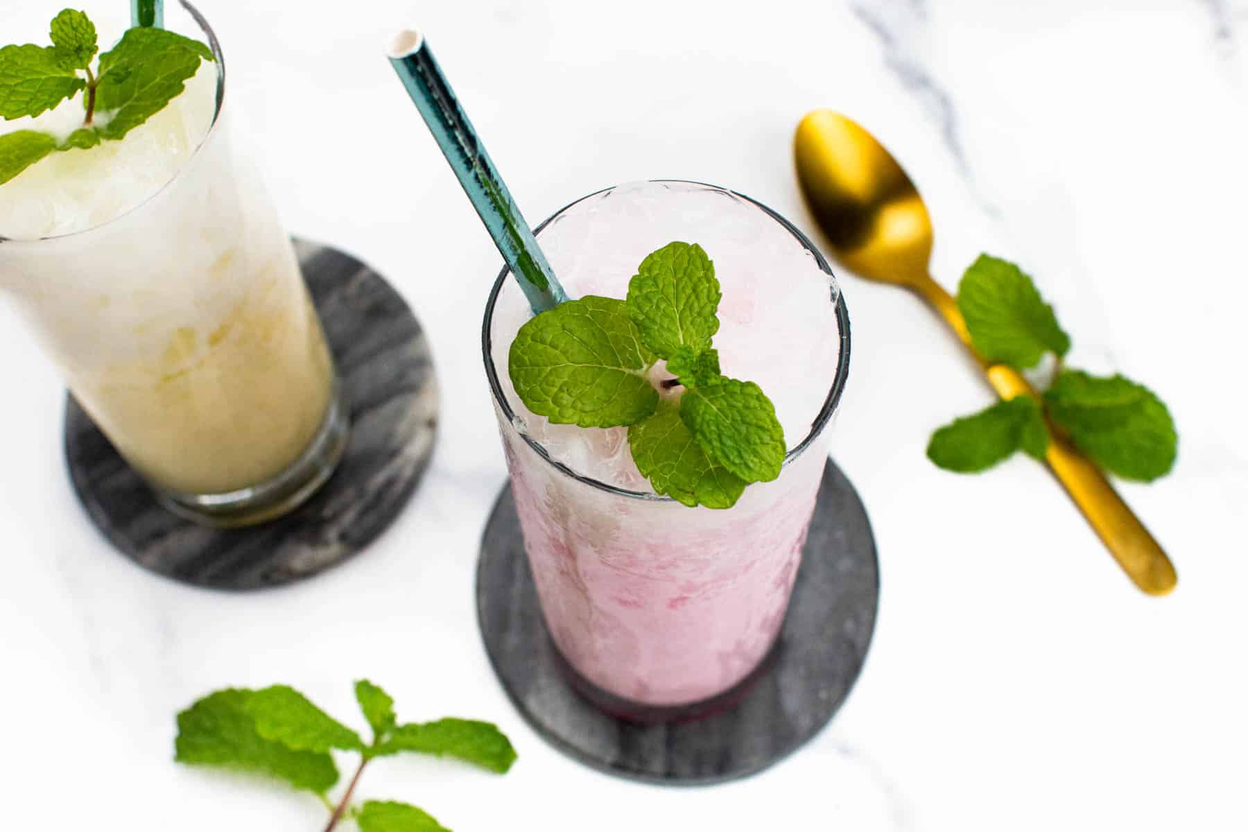 An overhead view of two creamy French sodas garnished with mint sprigs.