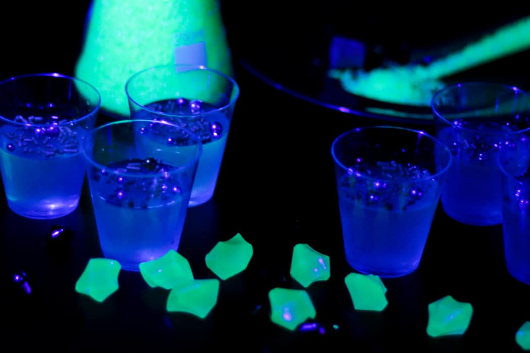 Glow-in-the-dark jello shots under a blacklight.
