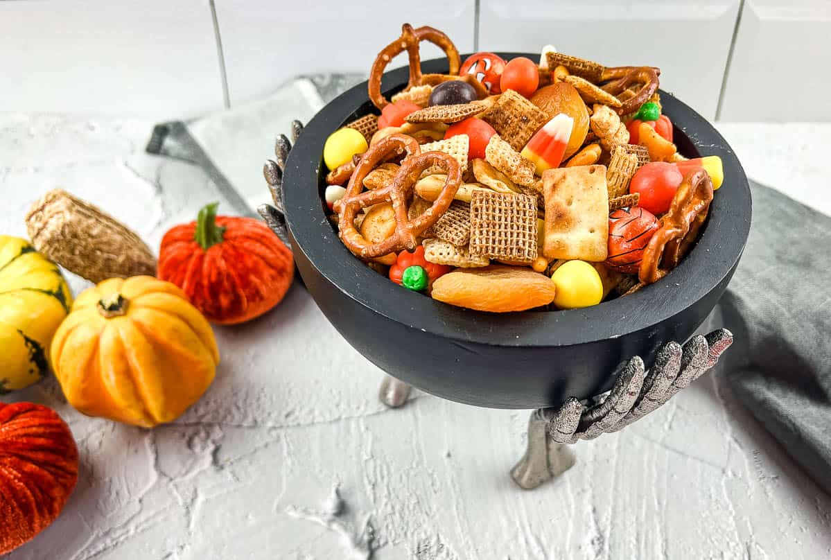 Spicy Chex Mix with Halloween Candies in a festive bowl.