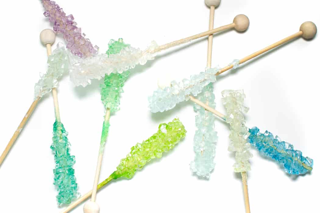 Colorful rock candy swizzle sticks on a white background.
