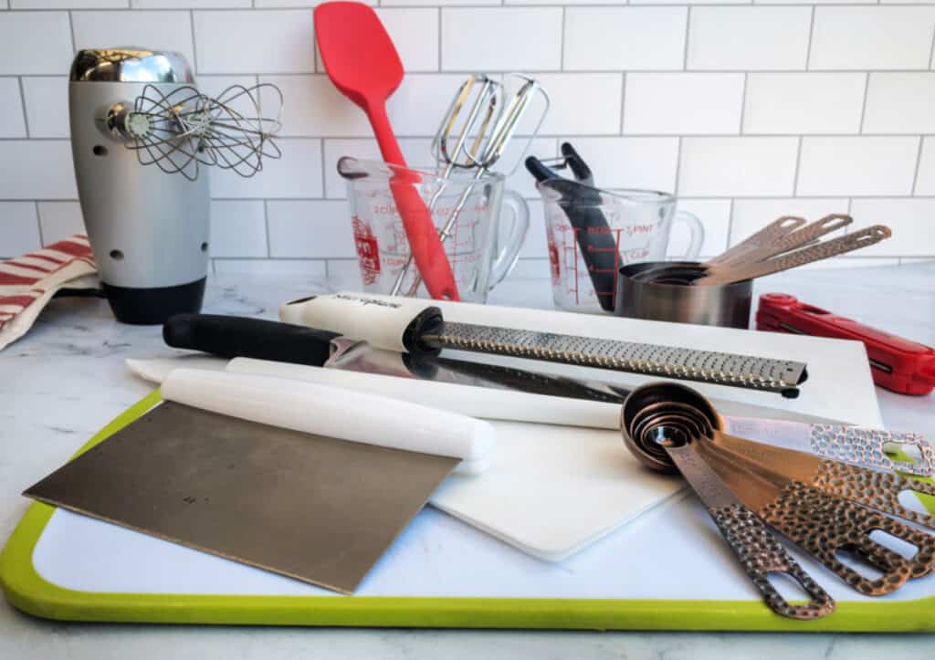 An assortment of kitchen utensils on a cutting board.