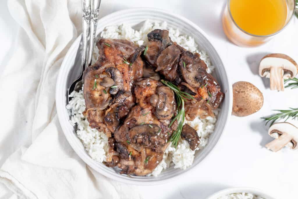 A bowl of rice with mushrooms and chicken marsala. 