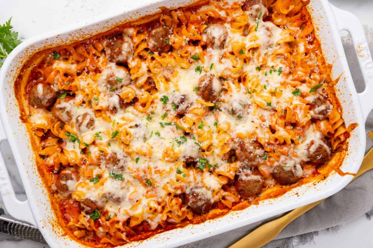 A casserole dish with meatballs and pasta.