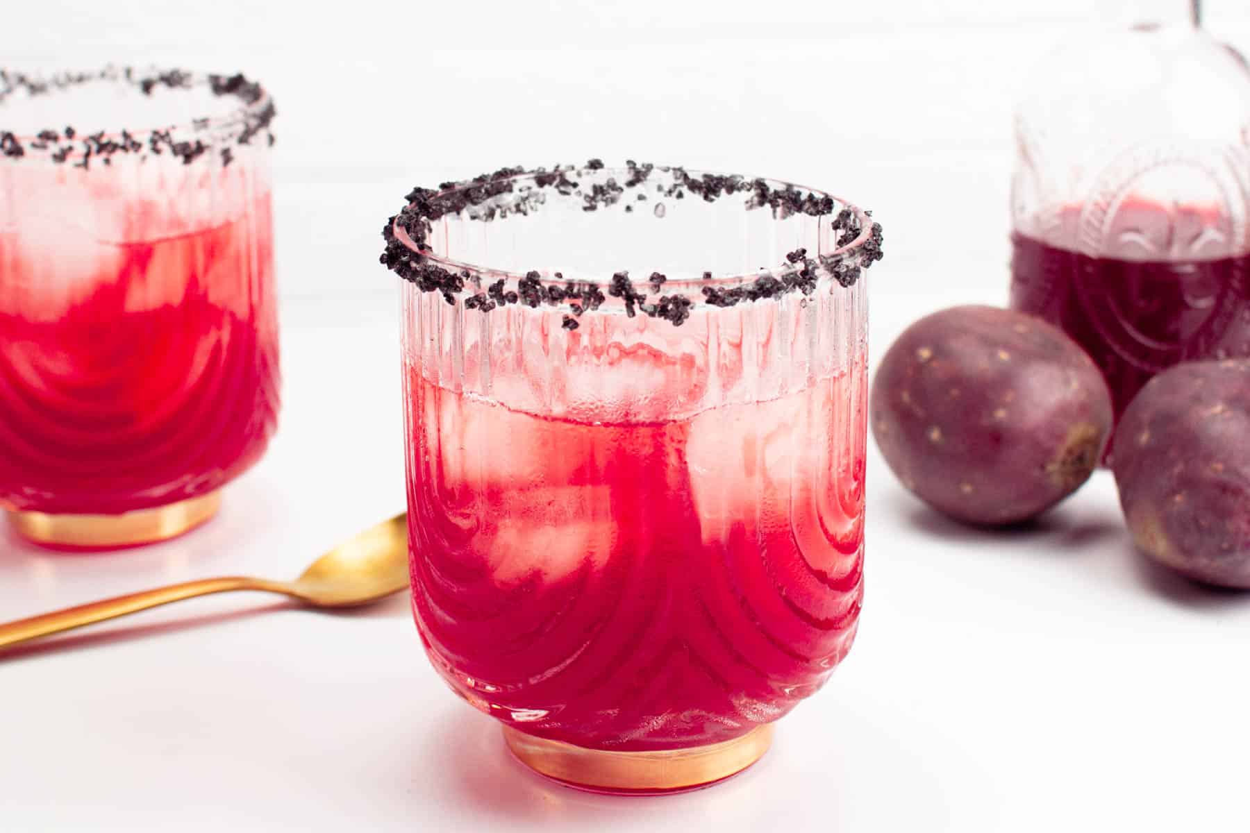 Two glasses of a red drink with a gold rim.