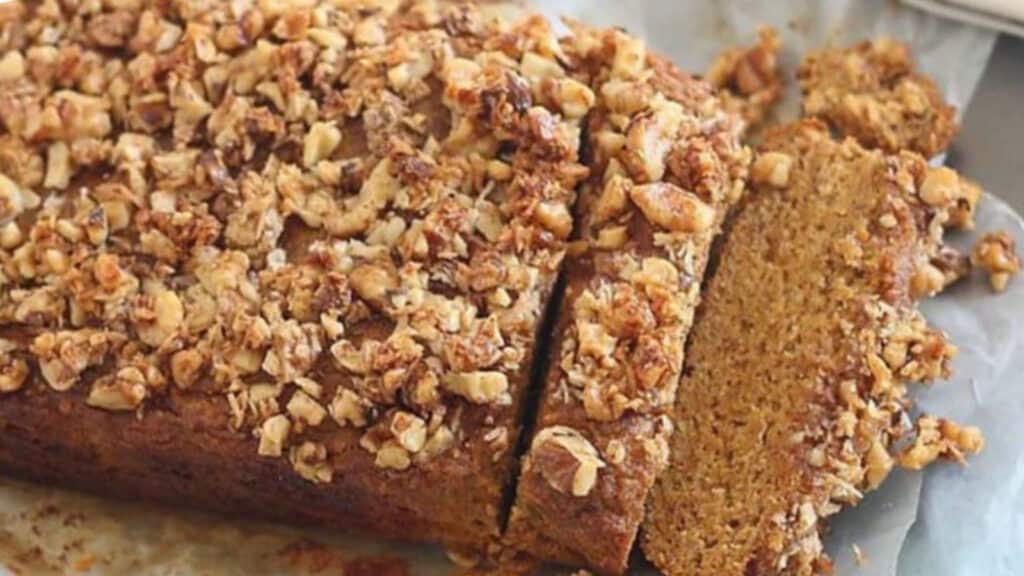 A slice of pumpkin bread with granola on top.