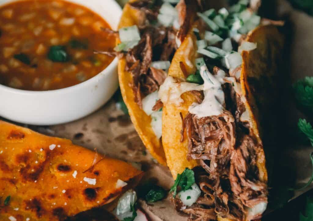 Mexican birria tacos with consumme for dipping.