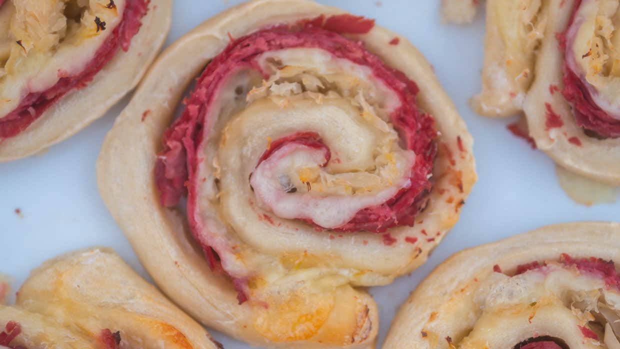 Cheesy Reuben rollups with pastrami and Swiss cheese.