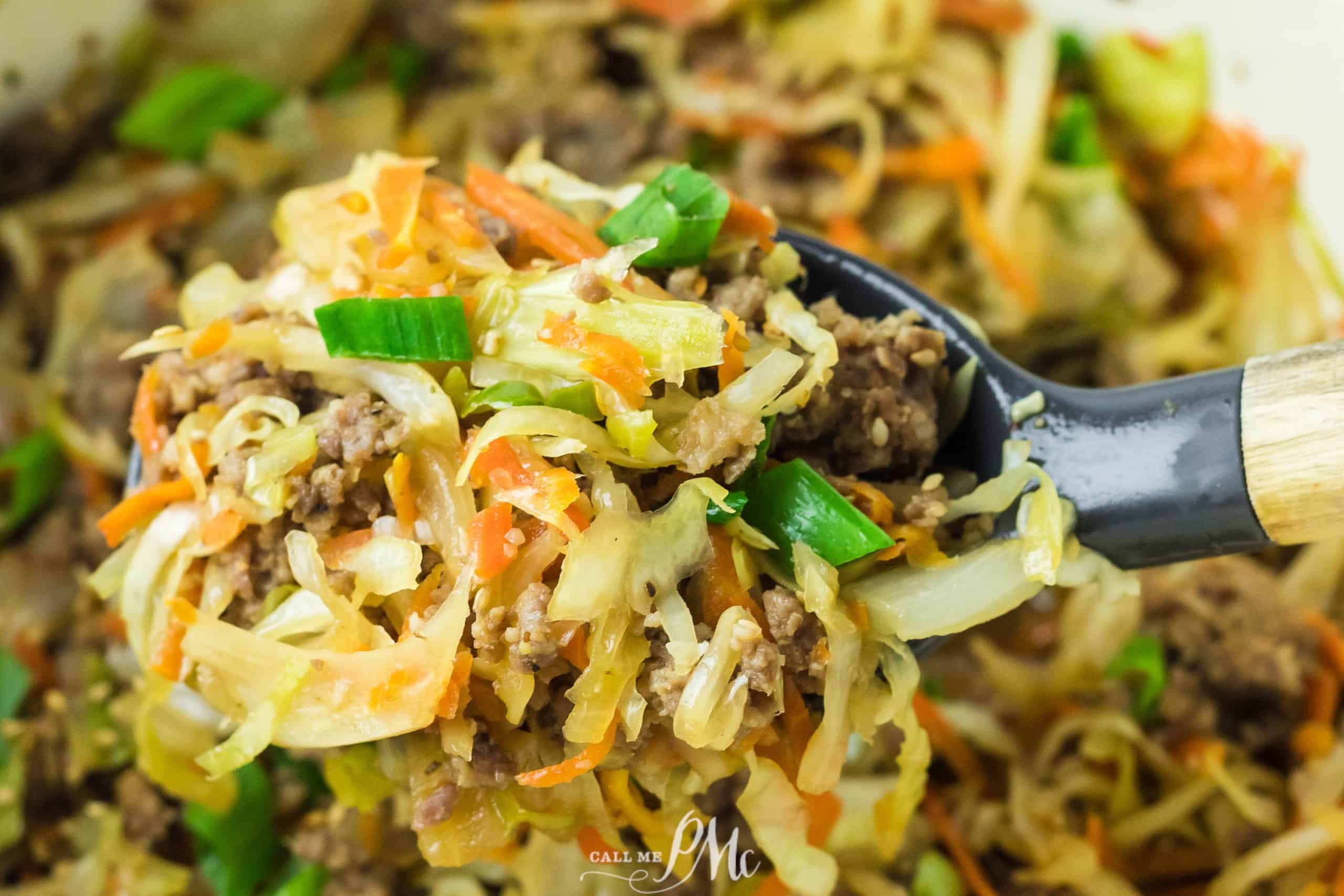 A spoonful of meat and cabbage in a pan.