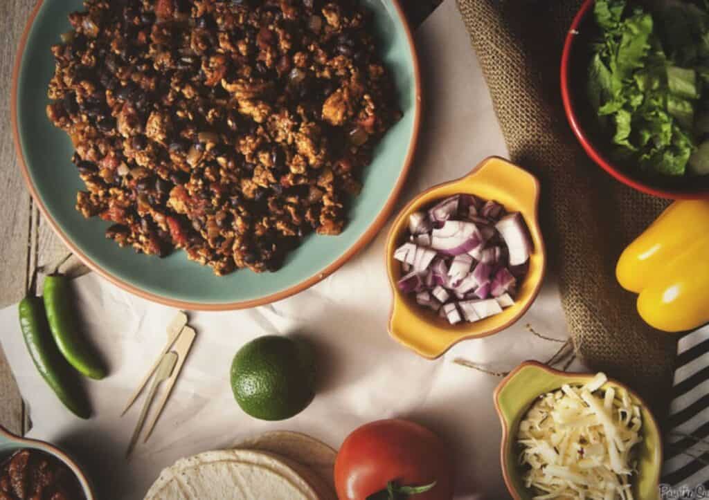 A plate of ground turkey taco meat and food on a table.