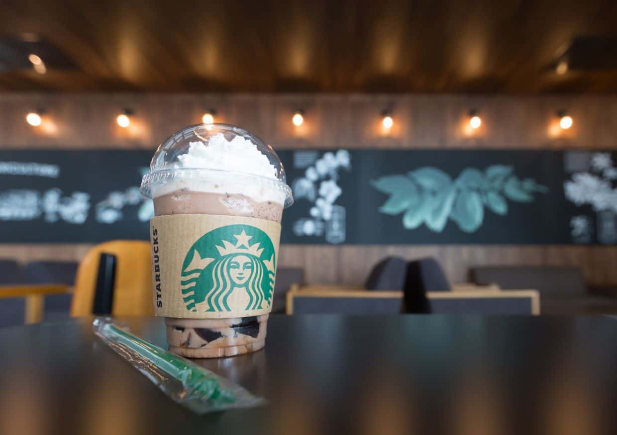 A secret menu Starbucks drink with whipped cream and a straw on a table.