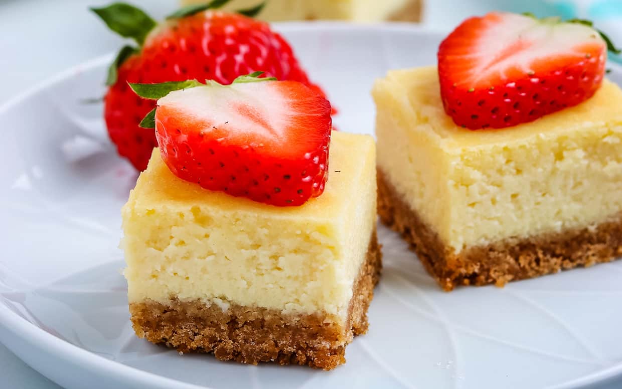 Cheesecake bar squares topped with sliced strawberries.