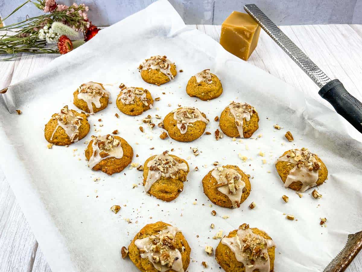 Sweet Potato Cookies on a baking sheet with icing and nuts.