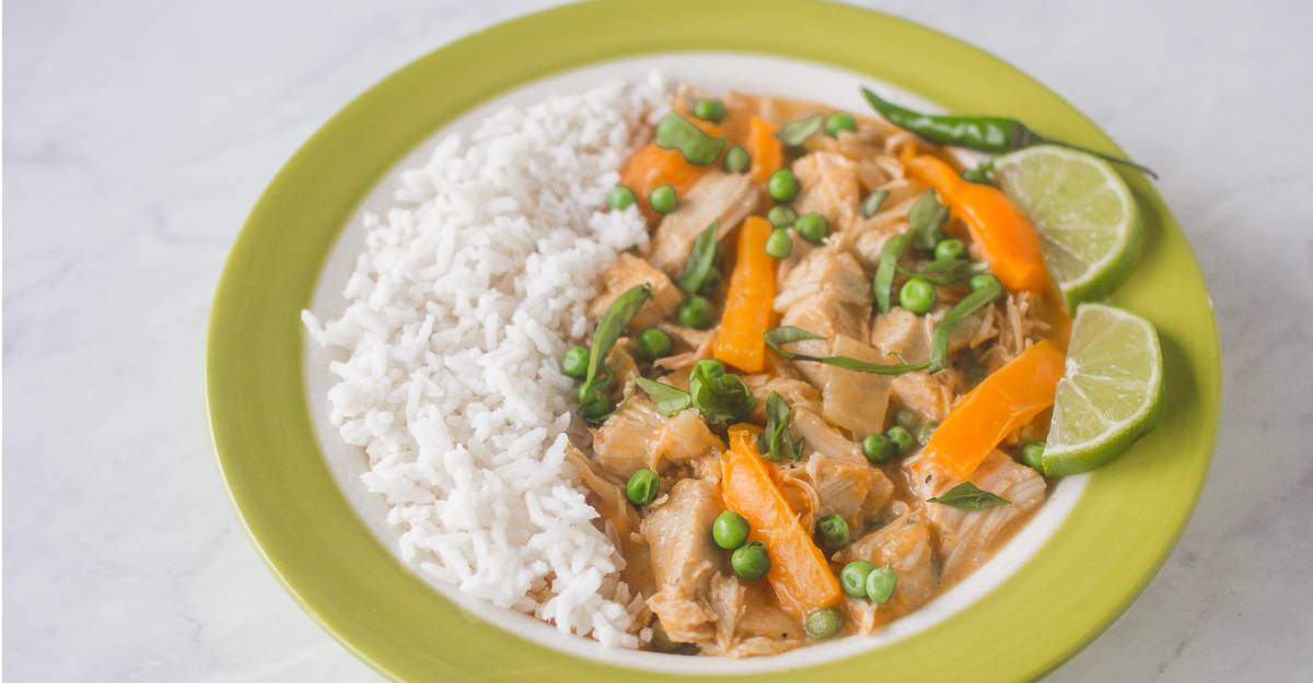 A plate of Thai chicken curry with rice and vegetables.