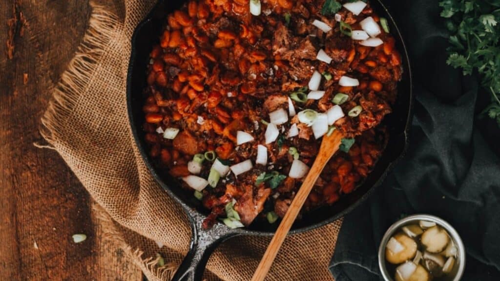 A skillet filled with beans and onions.