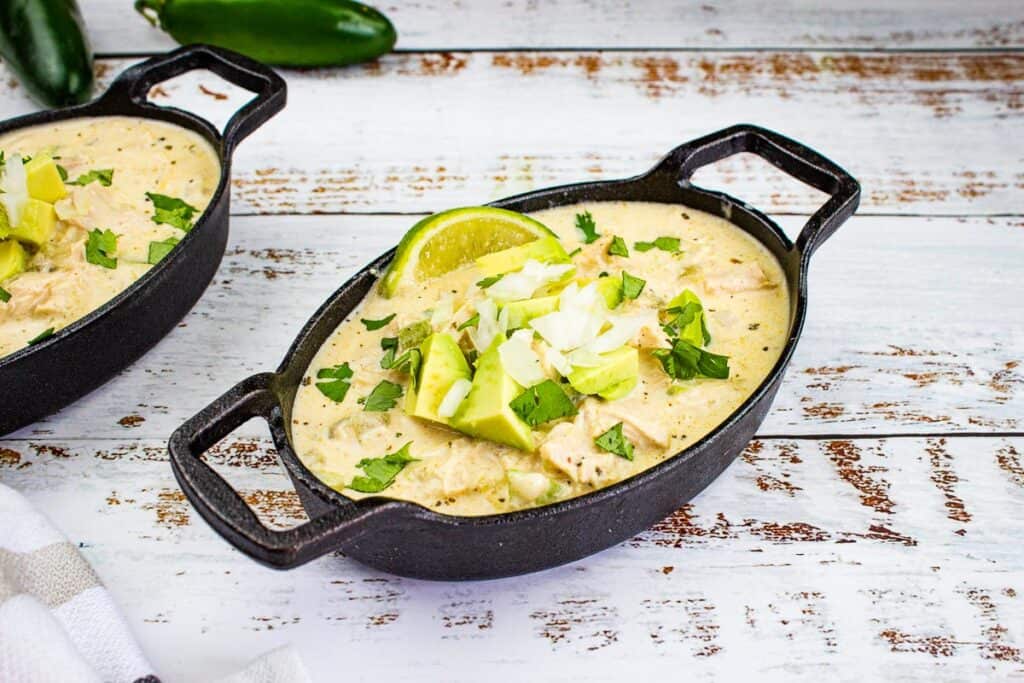 Two bowls of White Chicken Chili on a wooden table.