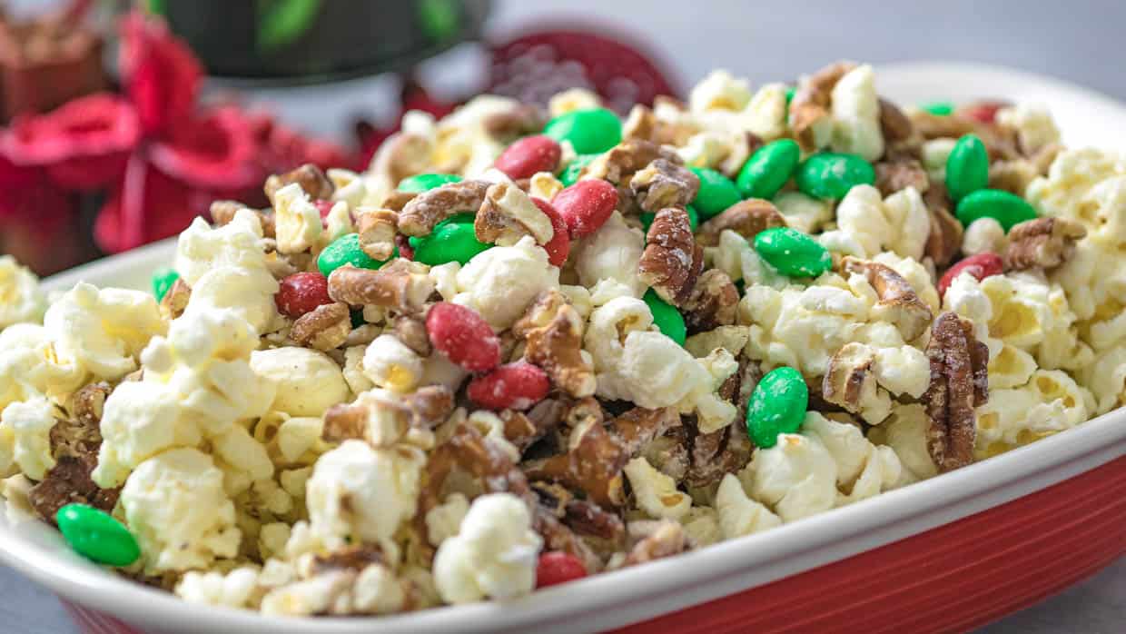 A bowl of popcorn with nuts and candy in it.