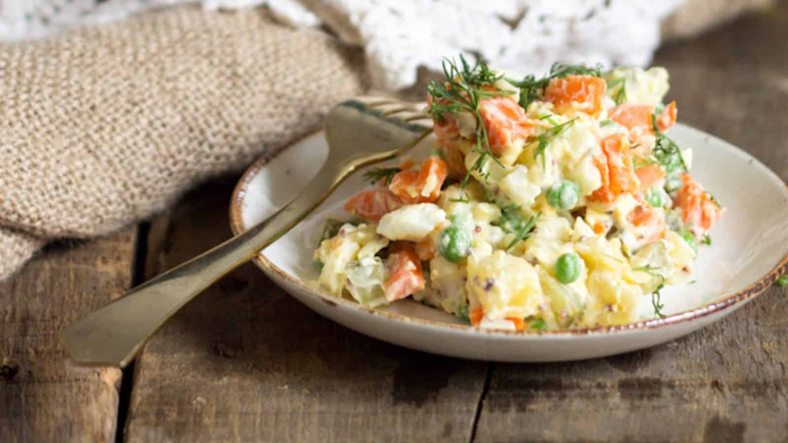 Overhead view of olivier salad with two egg halves.