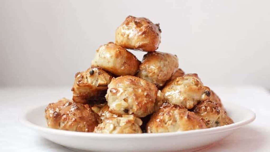 A stack of doughnuts on a white plate.