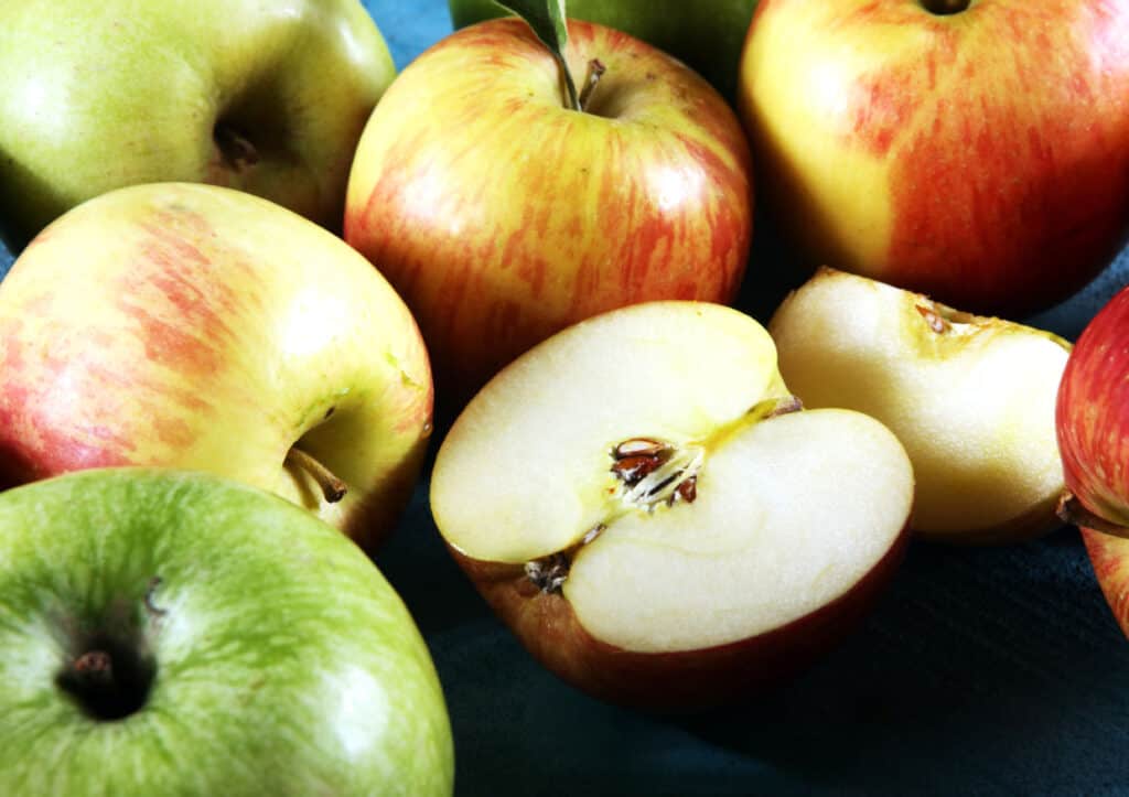 A bunch of apples on a blue table.