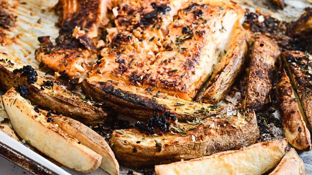 Grilled salmon and potatoes on a baking sheet.