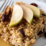 Oatmeal with apples and cranberries on a white plate.