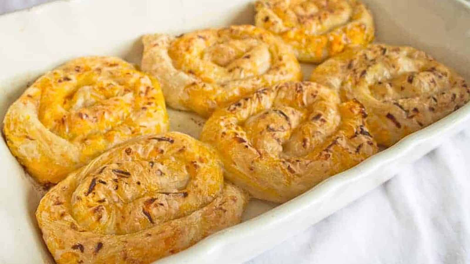 Cheesy cinnamon rolls in a white baking dish.