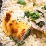 Chicken stuffed with spinach and cheese on a bed of rice.