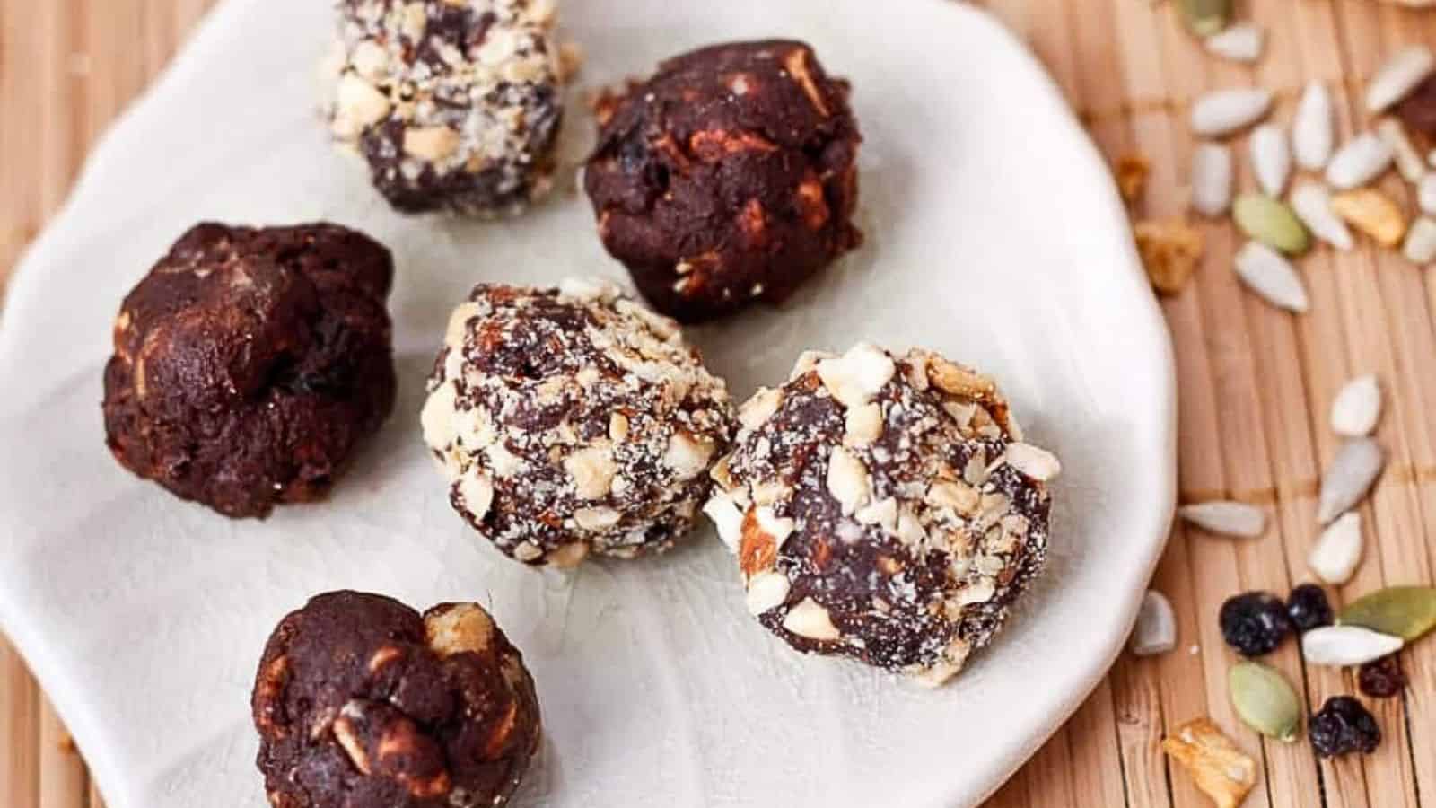 Chocolate and raisin energy bites on a white plate.