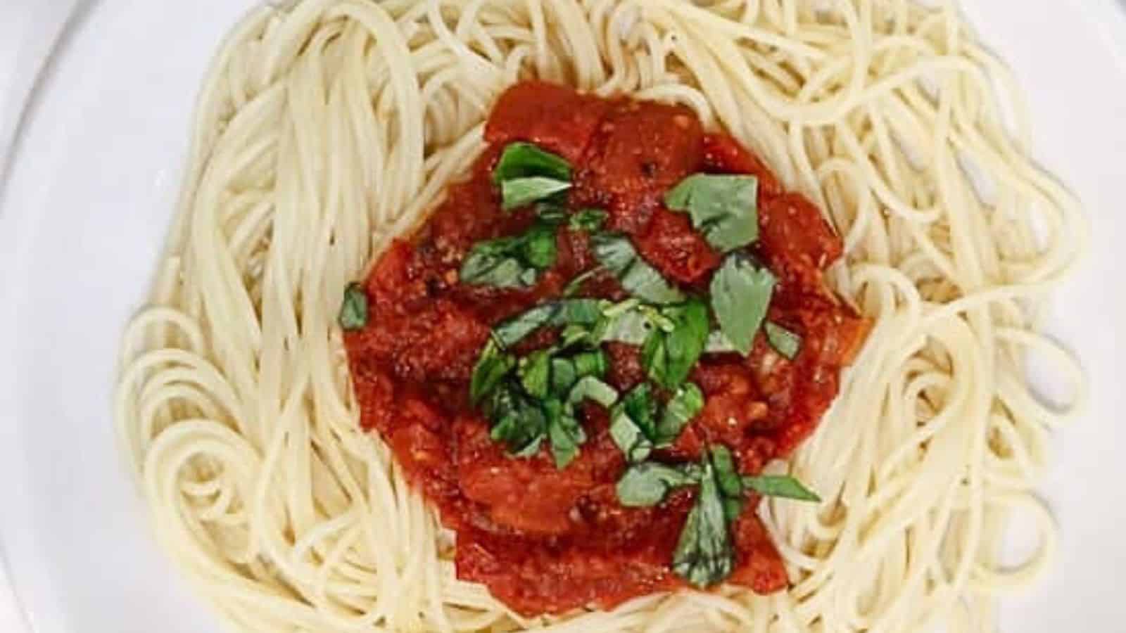 Spaghetti with tomato sauce on a white plate.