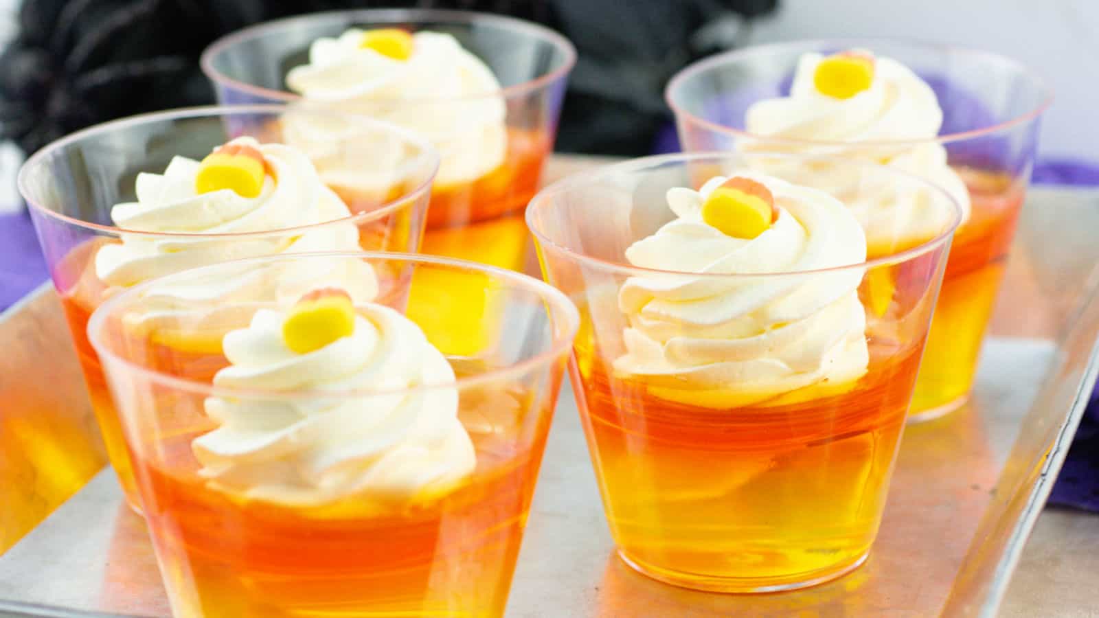Orange and yellow Jello dessert cups on a tray.