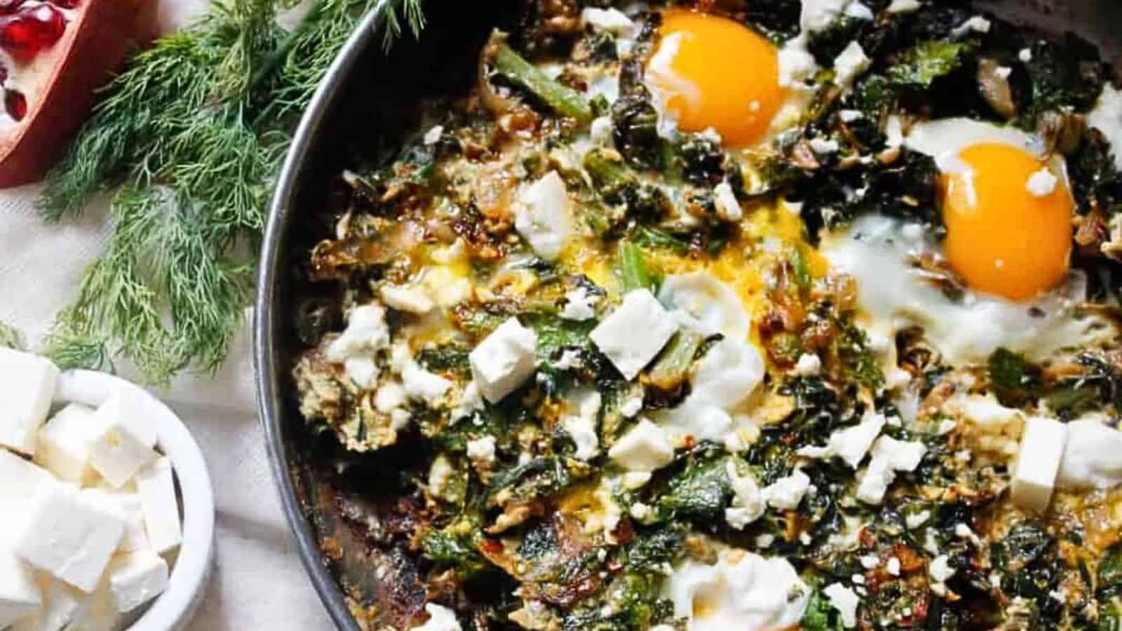 A skillet with eggs, spinach and pomegranate.