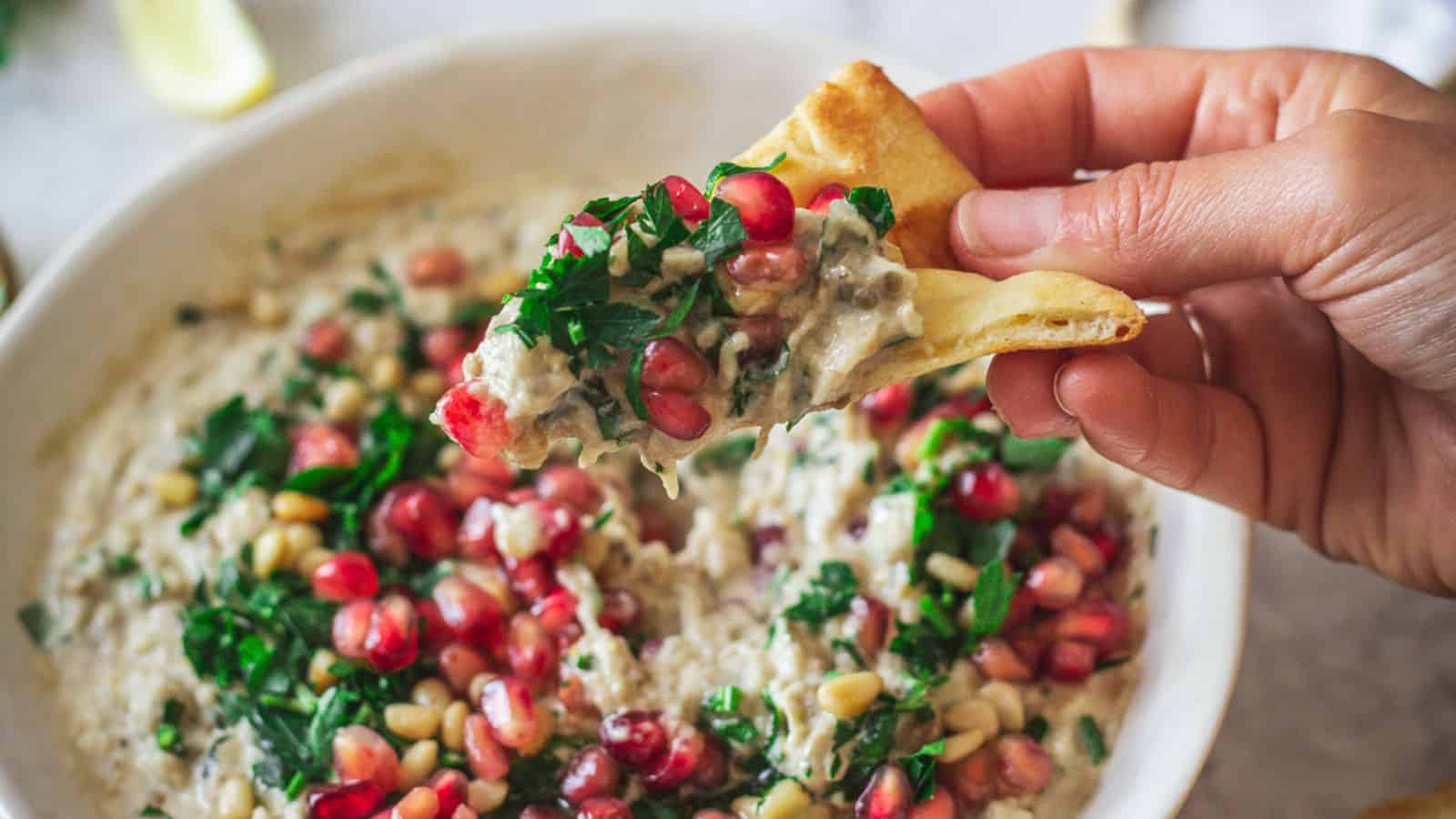 Baba ganoush on a plate with pomegranate seeds, parsley.